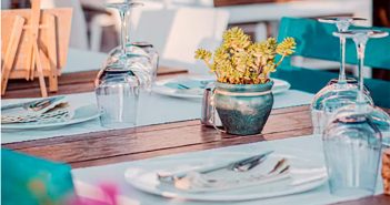 mesa de restaurante con copas y florero