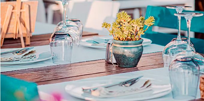 mesa de restaurante con copas y florero
