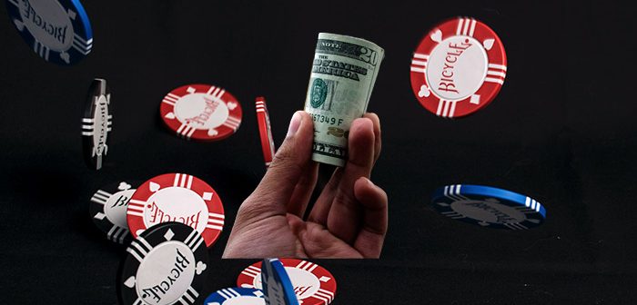 mano con dinero y fichas de juego